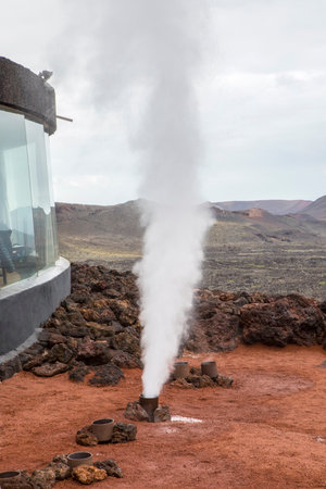 One of the various Geothermal experiments which they show to tourists at the Timanfaya National Park in Lazarote.  Water is poured into holes of a dormant volcano which boils instantly and shoots into the air with a bang.の写真素材