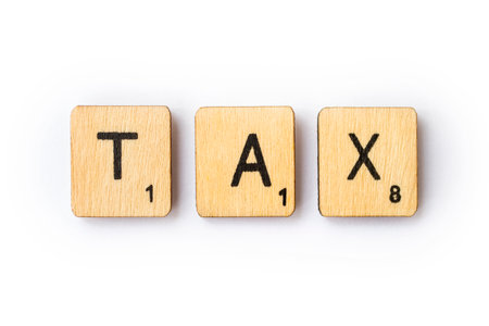 LONDON, UK - JUNE 28TH 2018: The word TAX spelt out with wooden letter Scrabble tiles, on 28th June 2018.のeditorial素材