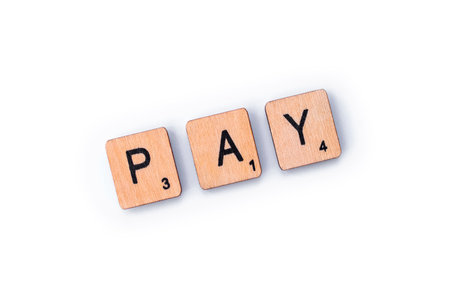 London, UK - February 6th 2019: The word PAY,spelt out with wooden letter Scrabble tiles.のeditorial素材