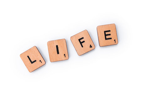 London, UK - February 6th 2019: The word LIFE, spelt out with wooden letter Scrabble tiles.のeditorial素材