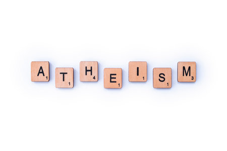 London, UK - February 6th 2019: The word ATHEISM, spelt out with wooden letter Scrabble tiles.のeditorial素材