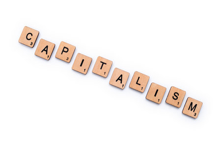 Photo pour London, UK - March 27th 2019: The word CAPITALISM, spelt with wooden letter tiles over a plain white background. - image libre de droit