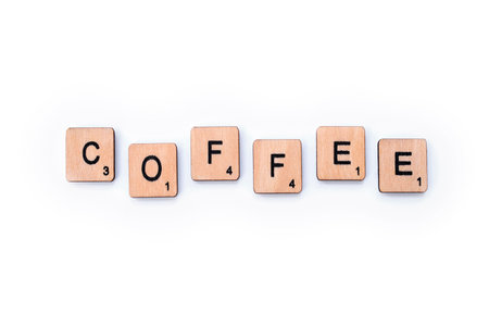 London, UK - March 27th 2019: The word COFFEE, spelt with wooden letter tiles over a white background.のeditorial素材