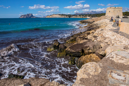 A beautiful view from the coastal town of Moraira, looking towards Calpe Rock and the town of Calpe in the Costa Blanca region of Spain.  The Castillo de Moraira, or Castle of Moraira, can also be seen.のeditorial素材