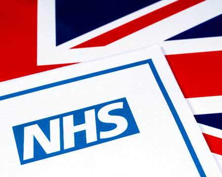 National Health Service, or NHS, logo with a UK flag background.の写真素材