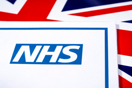 National Health Service, or NHS, logo with a UK flag background.の写真素材