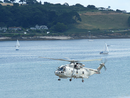 Helicopter hovering over bay, Falmouth, Cornwall, UK