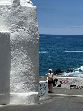 A tourist looking out to sea, Puerto de la Cruz, Tenerife, Canariesの写真素材