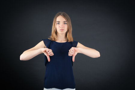 Beautiful woman doing different expressions in different sets of clothes: thumbs downの写真素材