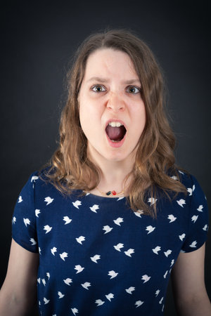 Beautiful woman doing different expressions in different sets of clothes: angryの写真素材