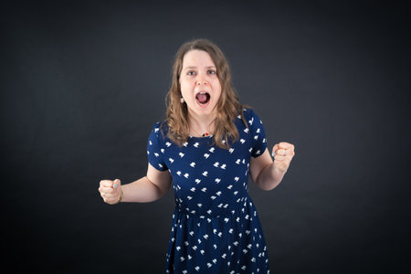 Beautiful woman doing different expressions in different sets of clothes: angryの写真素材