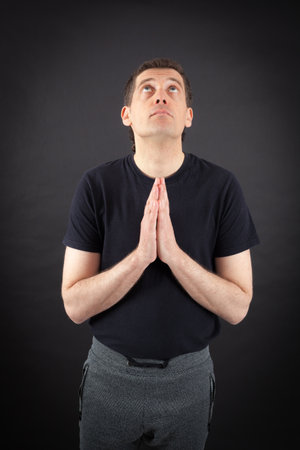 Handsome man doing different expressions in different sets of clothes: prayerの写真素材