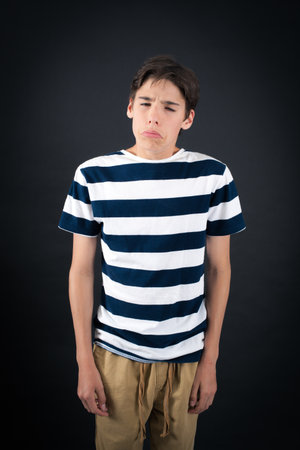 Handsome boy doing different expressions in different sets of clothes: sadの写真素材