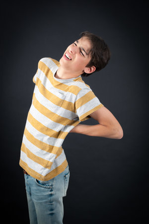 Handsome boy doing different expressions in different sets of clothes: backacheの写真素材