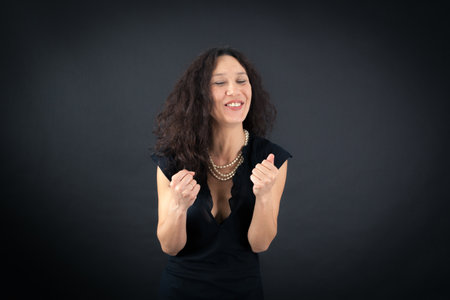 Beautiful woman doing different expressions in different sets of clothes: arms raisedの写真素材