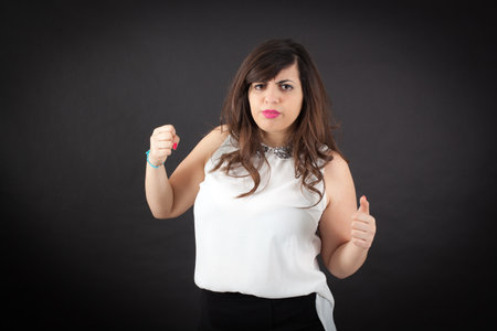 Beautiful woman doing different expressions in different sets of clothes: angryの写真素材