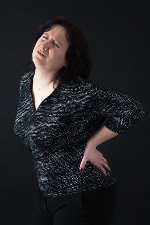 Beautiful woman doing different expressions in different sets of clothes: backacheの写真素材