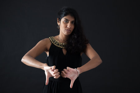 Beautiful woman doing different expressions in different sets of clothes: thumbs downの写真素材