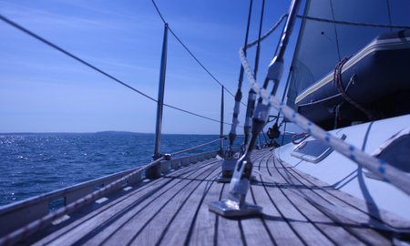 view along the teak deck of a sailing yacht looking out to sea