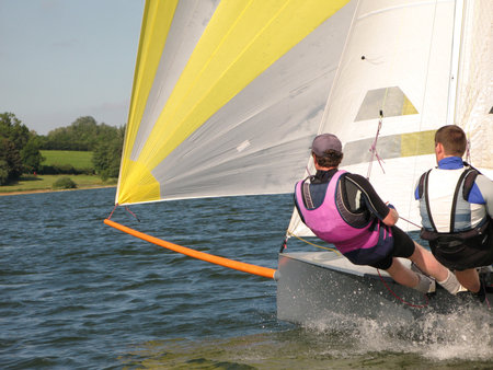 two people sailing a small grey dinghy on a lakeの写真素材