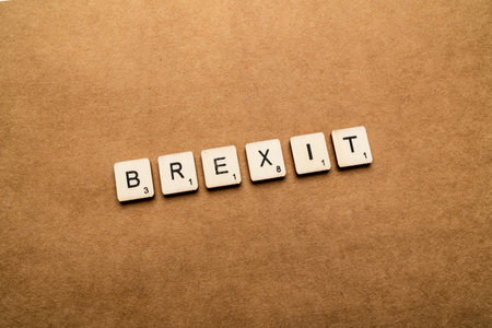 LONDON, UK - May 24 2019: The word BREXIT, spelt with wooden letter tiles over a brown textured backgroundのeditorial素材