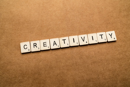 LONDON, UK - May 24 2019: The word CREATIVITY, spelt with wooden letter tiles over a brown textured backgroundのeditorial素材