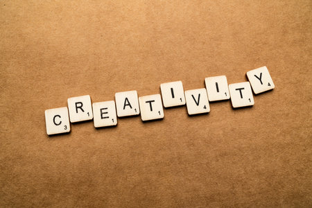 LONDON, UK - May 24 2019: The word CREATIVITY, spelt with wooden letter tiles over a brown textured backgroundのeditorial素材