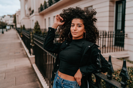 Portrait Charming Young African Woman with Curly Hair, Street Style, Posing Outdoorsの写真素材