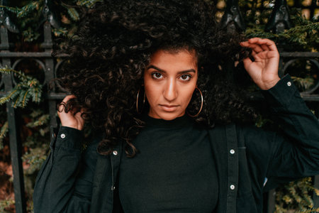 Portrait Charming Young African Woman with Curly Hair, Street Style, Posing Outdoorsの写真素材
