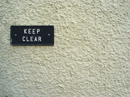 Keep Clear sign on a cream stone wallの写真素材
