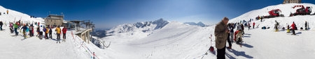KASPROWY WIERCH, POLAND - APRIL 11, 2015: Panorama of ski resort on winter sunny day. Highest slop in Poland. Skiers enjoying good weather on the end of season. Skiing in Polish Kasprowy Wierch on sunny day located on Poland - Slovakia borderのeditorial素材