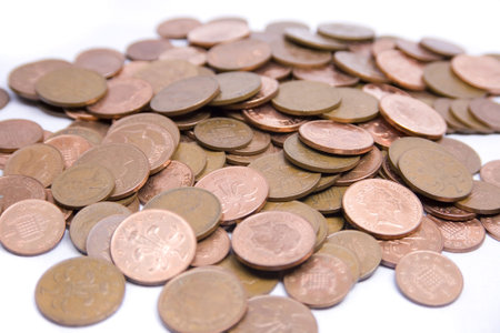 Hundreds of penny and two pence coins sit on a white background.の写真素材