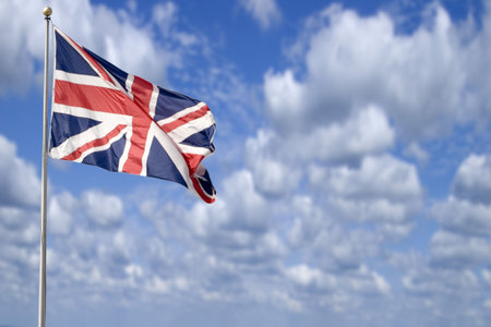 A british flag (The Union Jack) flying in the breeze set against a beautiful summer sky.の写真素材