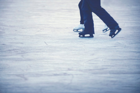 Ice skating couple - Legs of woman and man with white and black skates.の写真素材
