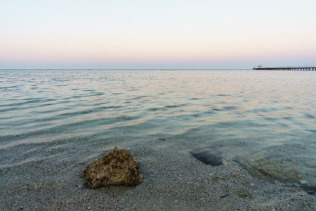 The Mediterranean Sea in the rays of the setting sun. Foam Waves and Sea Sandの写真素材