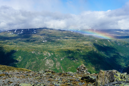Beautiful rainbow over mountains during sunsetin the WIlderness of Norway twoの写真素材