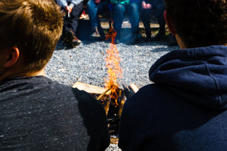 People sit round a bright bonfireの写真素材
