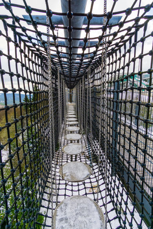 the childrens bridge made of logs and chainsの写真素材