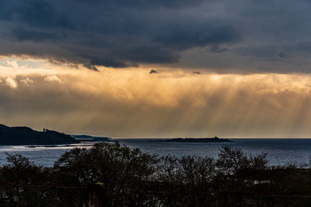 Calm seascape with stormy sky where sun-rays get through the clouds.の写真素材
