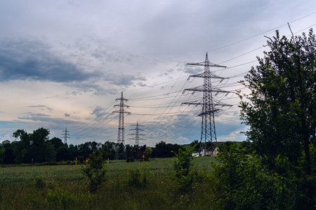 Dramatic black and white of Electricity transmission power lines and post against blue sky at...