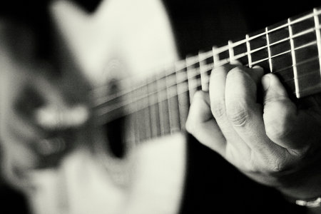 Hand playing a classical guitar