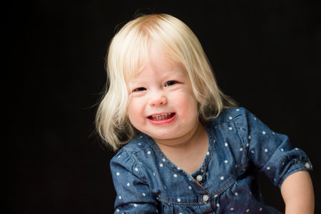 Happy toddler smiling against black backgroundの写真素材