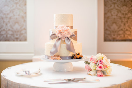 White wedding cake and bouquet with Roses, Dusty Miller, Ranunculus