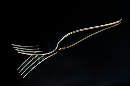 A high contrast image of a fork on a mirrorの写真素材