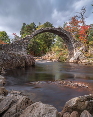 An old cart bridge made of stone over a river in Scotland, taken with a long exposure