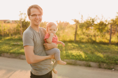 Father and baby daughter outside in the sunsetの写真素材