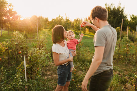 Parents and baby daughter outside in the sunsetの写真素材