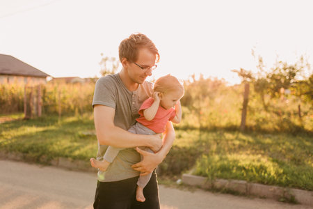 Father and baby daughter outside in the sunsetの写真素材