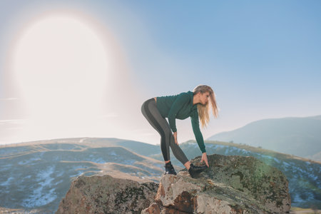 Young fit woman exercising on a mountain top