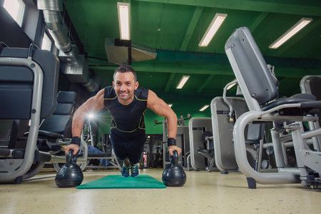 Man doing pushups in the gym on the floor